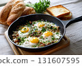 Sunny side up eggs with herbs and bread in skillet create delicious breakfast scene. fresh parsley adds touch of color and flavor, complementing crispy bread 131607595