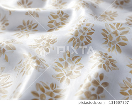 White fabric with floral pattern in gold tones, showcasing intricate design details and soft texture. fabric appears elegant and luxurious, suitable for home decor or fashion 131607597