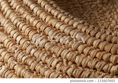 Close up of woven straw mat texture showcases intricate patterns and natural fibers, highlighting craftsmanship and earthy tones. detailed view emphasizes texture and structure 131607605