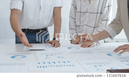 Group of business people is collaborating in modern office environment, analyzing financial data and charts, evaluating performance and developing company growth strategy Group of business people is collaborating in modern office environment, analyzing financial data and charts, evaluating performance and developing company growth strategy 131607616