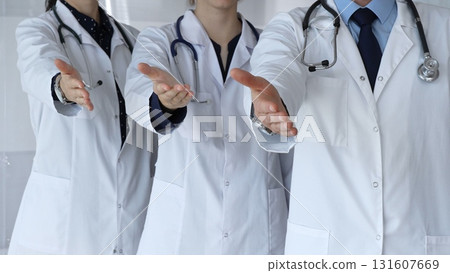 Medical team reaching out presenting helping hands, offering partnership, support, health care, and welcome, symbolizing trust and collaboration in medicine Medical team reaching out presenting helping hands, offering partnership, support, health care, and welcome, symbolizing trust and collaboration in medicine 131607669