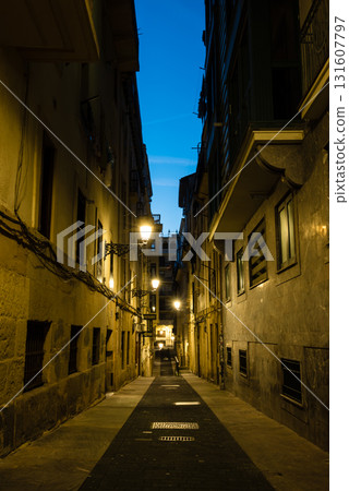 西班牙聖塞瓦斯蒂安老城黎明前：空蕩蕩的鵝卵石街道、路燈和歷史建築 131607797