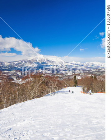 A high-altitude ski course with a view of the majestic snow-capped Mt. Myoko on a clear day (Madarao Kogen, Nagano Prefecture) 131607969