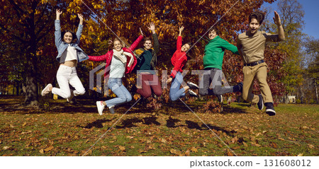 Group of a young happy smiling friends walking and jumping in the autumn park. 131608012