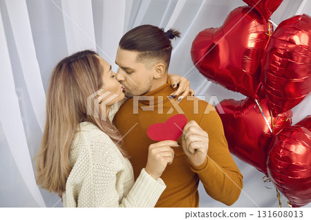 Sweet, young, romantic couple celebrating St Valentine's Day, hugging and kissing 131608013