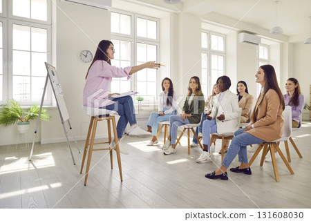 Group of business women on a meeting listening a woman speaking at the conference. 131608030