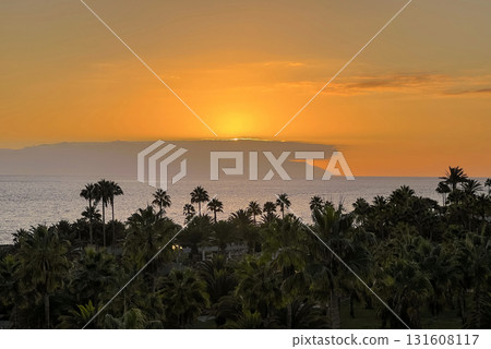 Sunset Over La Gomera island. View from Tenerife with Dramatic Clouds and Silhouetted Palms Sunset Over La Gomera island. View from Tenerife with Dramatic Clouds and Silhouetted Palms 131608117