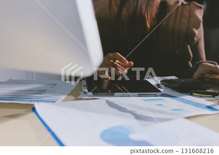 Close-up of businessman's hands making notes, mobiles, chart, desk, office Close-up of businessman's hands making notes, mobiles, chart, desk, office 131608216