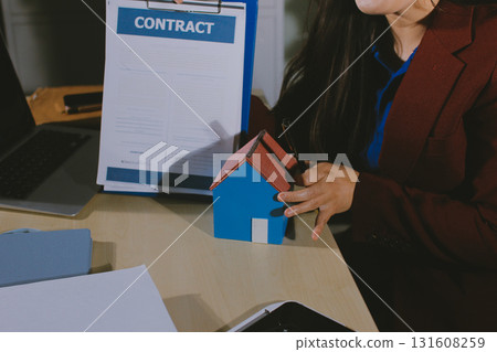 Customer signing a real estate contract in real estate agency. Customer signing a real estate contract in real estate agency. 131608259