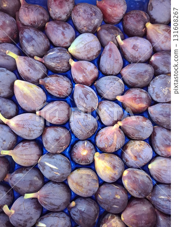 Bright, ripe figs fill a blue crate, displaying their rich colors and textures. These figs are freshly harvested, ready for sale at a local market. Bright, ripe figs fill a blue crate, displaying their rich colors and textures. These figs are freshly harvested, ready for sale at a local market. 131608267