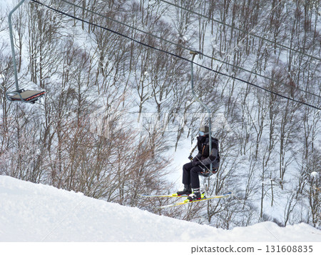 A skier rides a single lift through the forest of snowy mountains at a ski resort (Madarao Kogen, Niigata Prefecture) A skier rides a single lift through the forest of snowy mountains at a ski resort (Madarao Kogen, Niigata Prefecture) 131608835