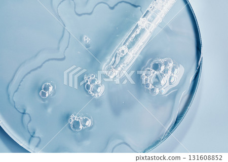 Clear gel serum with bubbles and dropper on petri dish surface Clear gel serum with bubbles and dropper on petri dish surface 131608852