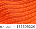 A close up of a knitted orange sweater 131609220