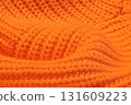 A close up of a knitted orange sweater 131609223