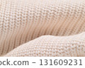 A close up of a white knit sweater with a fuzzy texture 131609231