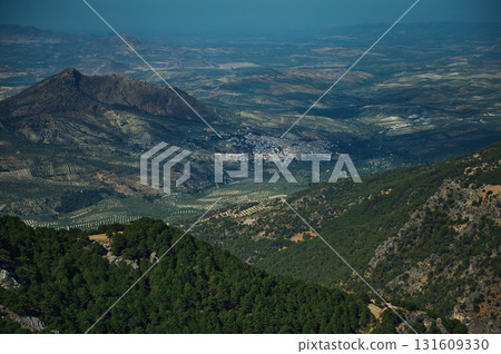 Aerial View Of Rolling Olive Groves And Mountain Village In An Expansive Andalusian Landscape Aerial View Of Rolling Olive Groves And Mountain Village In An Expansive Andalusian Landscape 131609330