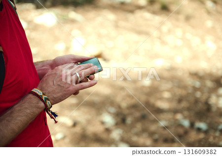Person In Red Shirt Using Smartphone Outdoors, Wearing Bracelet And Ring 131609382