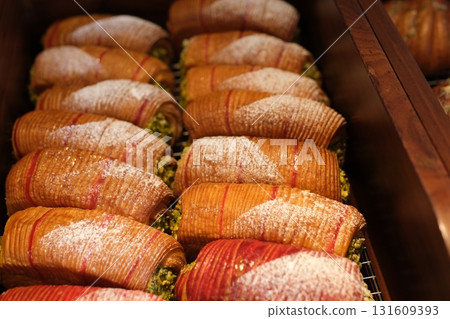 Closeup of delicious sicilian cannoli, a traditional italian dessert filled with ricotta and pistachios, european food  131609393