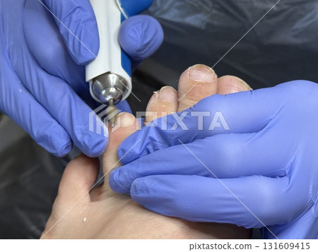 Pedicure specialist shaping nails with precision using professional nail polish drilling tool. Beauty salon self-care routine healthy nails treatment and small business daily workflow 4K video 131609415