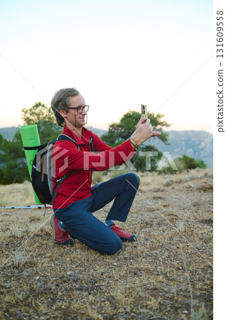 Outdoor Adventure Selfie: Hiker With Backpack Takes Photo On Trail At Sunset 131609558