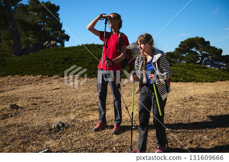 Two Hikers With Trekking Poles Exploring a Sunny Trail Together on an Outdoor Adventure Two Hikers With Trekking Poles Exploring a Sunny Trail Together on an Outdoor Adventure 131609666