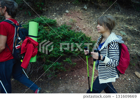 Hikers With Backpacks and Trekking Poles Walking on Rocky Trail Hikers With Backpacks and Trekking Poles Walking on Rocky Trail 131609669