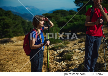 Hiking Partner On Mountain Trail With Trekking Poles And Backpacks 131609673