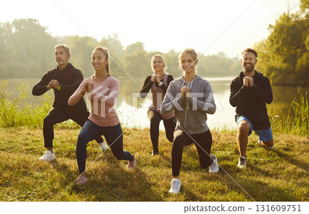 Active people doing stretching exercising in nature. Outdoors fitness concept. 131609751