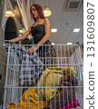 Young Man Taking Clothes Out of the Washing Machine in Self-Service 131609807
