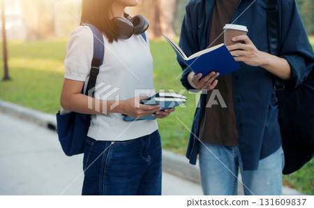 Happy students walking together on university campus, chatting and laughing outdoors after classes Happy students walking together on university campus, chatting and laughing outdoors after classes 131609837