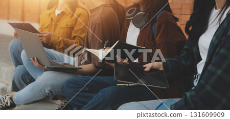Happy students walking together on university campus, chatting and laughing outdoors after classes 131609909
