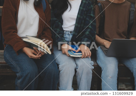 Happy students walking together on university campus, chatting and laughing outdoors after classes 131609929