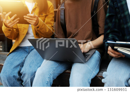 Happy students walking together on university campus, chatting and laughing outdoors after classes 131609931