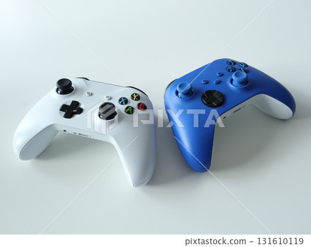White and Blue Game Controllers Pair On Smooth Surface For Gaming And Entertainment White and Blue Game Controllers Pair On Smooth Surface For Gaming And Entertainment 131610119