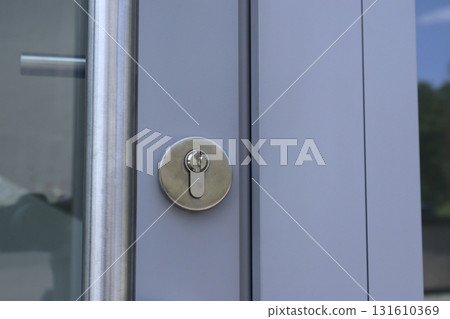Close-Up Of Modern Glass Door Lock On Light Blue Exterior Metal Frame Close-Up Of Modern Glass Door Lock On Light Blue Exterior Metal Frame 131610369