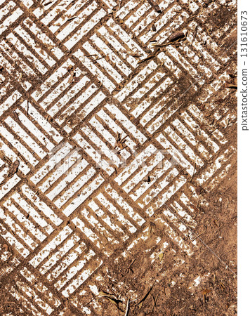 Geometric white pattern on ground texture. Abstract white geometric pattern on earthy textured ground with lines and symmetry. Background for design or texture use. Geometric white pattern on ground texture. Abstract white geometric pattern on earthy textured ground with lines and symmetry. Background for design or texture use. 131610673