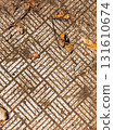 White geometric ground pattern with dry leaves. Abstract white geometric pattern on earthy surface with scattered dry leaves. Nature background and texture. 131610674