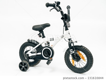 Modern white kids bike with training wheels, photographed for catalog. Perfect for online shops, family lifestyle visuals and sport retail promotion 131610844