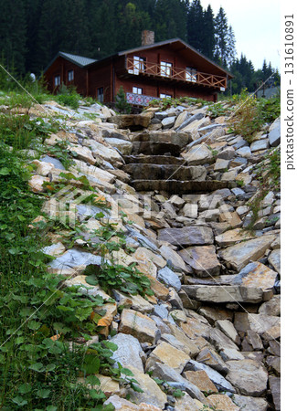 Small Trickle Flows Down The Stone Slabs And Rocks From Country Wooden House On A Hillock  131610891