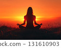 Silhouette of a woman practicing yoga at sunset 131610903
