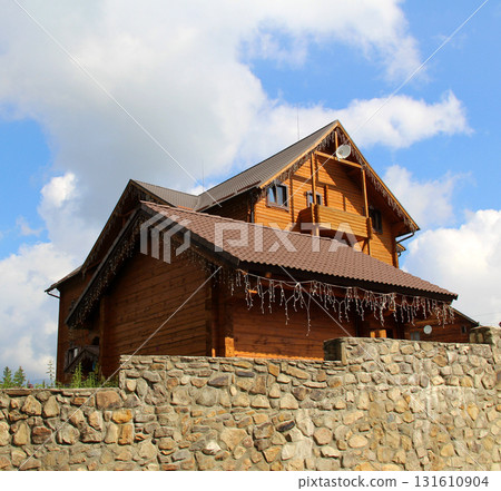 Massive stone wall in front of a two story log private cottage restricts private territory stock photo Massive stone wall in front of a two story log private cottage restricts private territory stock photo 131610904