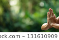 Detail of a woman's hands in a yoga pose outdoors 131610909