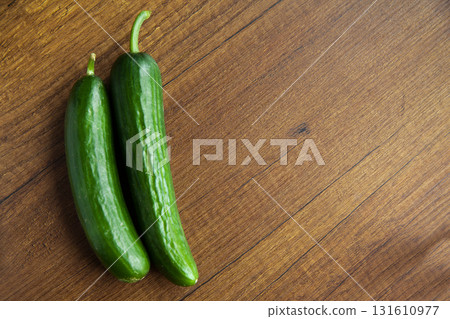 Fresh, tasty organic vegetables cucumber, isolated on brown wood cutting board 131610977