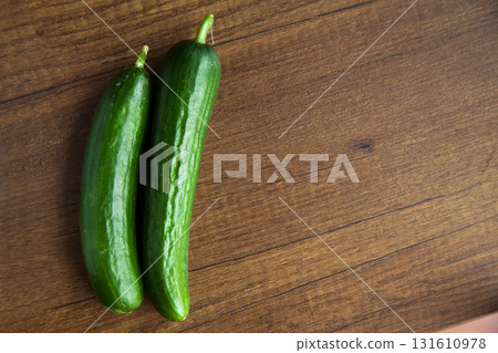 Fresh, tasty organic vegetables cucumber, isolated on brown wood cutting board 131610978