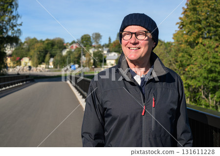 Portrait of a smiling senior man in sportswear on the bridge 131611228