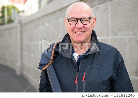 Portrait of a smiling senior man wearing glasses and a jacket. Portrait of a smiling senior man wearing glasses and a jacket. 131611240