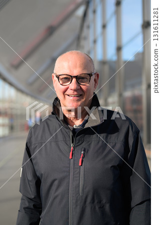 Portrait of a smiling senior man with eyeglasses at the railway station Portrait of a smiling senior man with eyeglasses at the railway station 131611281
