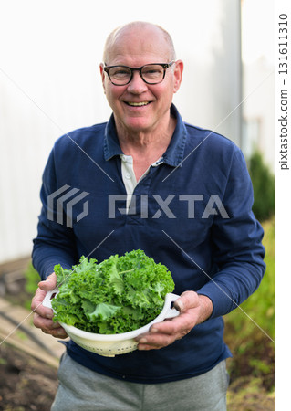 Portrait of a senior man holding a bowl of salad in his garden Portrait of a senior man holding a bowl of salad in his garden 131611310