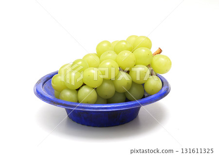 Grapes on a blue plate on a white background Grapes on a blue plate on a white background 131611325
