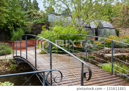 Vintage greenhouse and bridge in a park Vintage greenhouse and bridge in a park 131611881